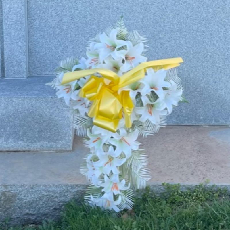 Easter Cross made of white lilies with a yellow ribbon