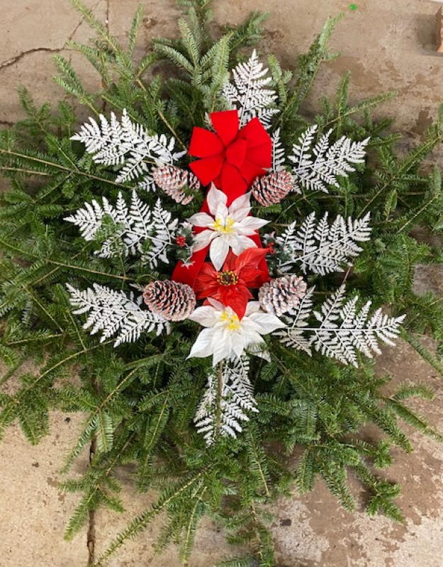 Evergreens with a red bow and white flowers